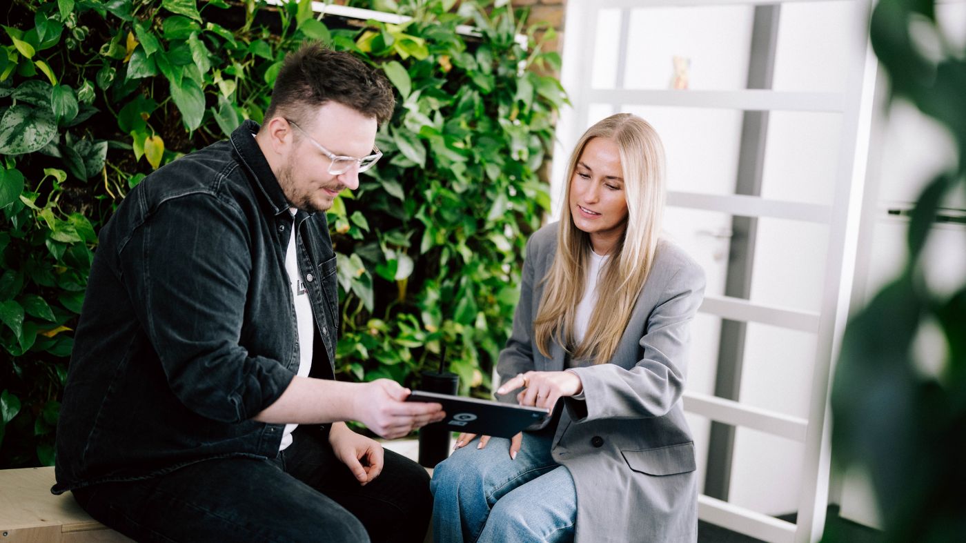 Flexible Systeme für Ihre Webseite Zwei Personen schauen gemeinsam auf ein Tablet in einem modernen Büro.