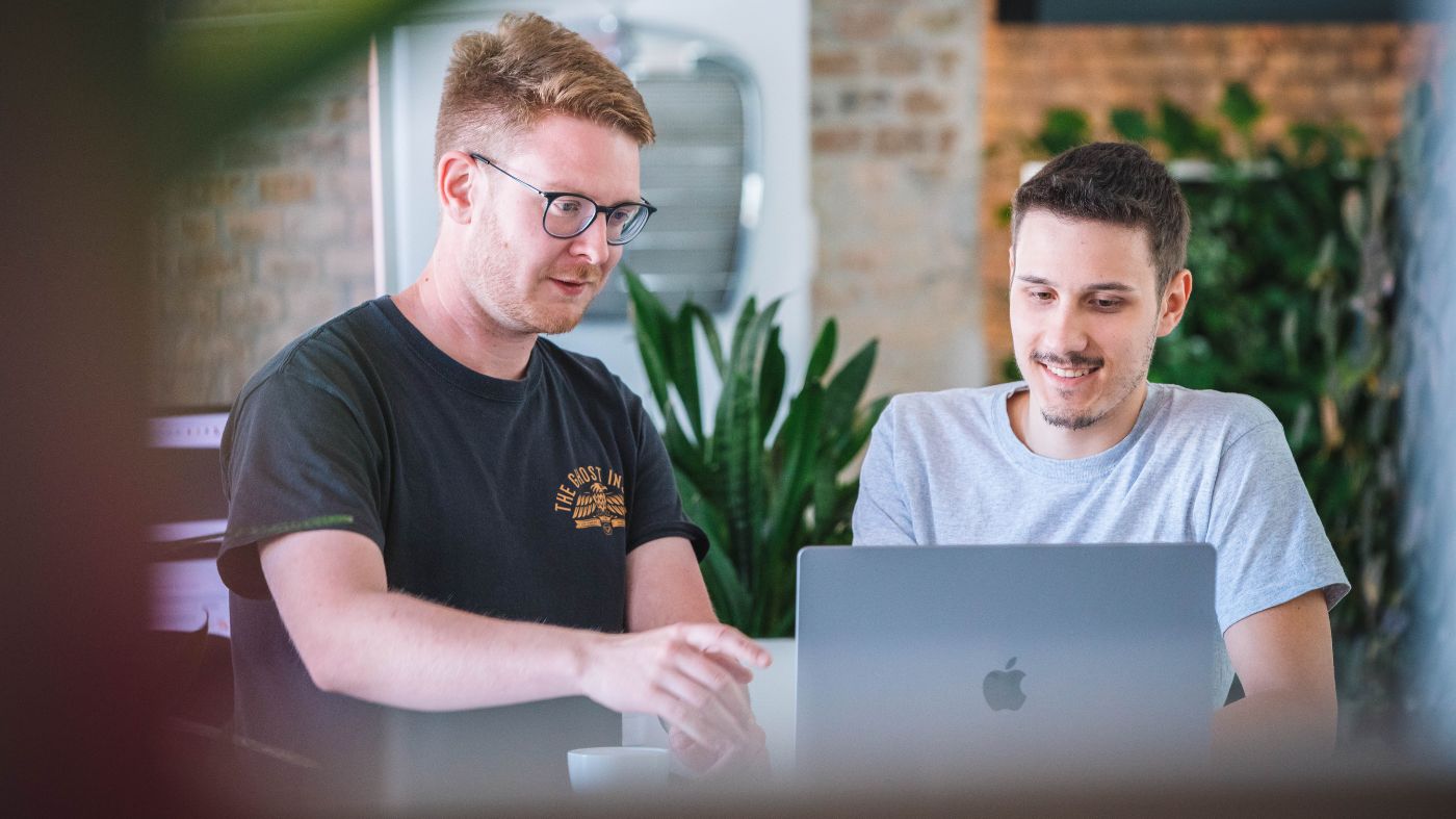 Marketing Agentur aus Stuttgart Zwei Männer arbeiten gemeinsam am Laptop in einem modernen Büro